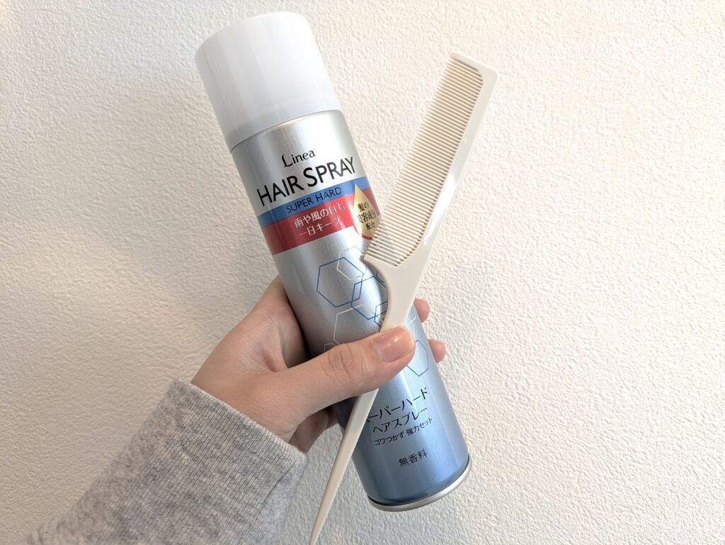 リネアヘアスプレー スーパーハードとコームをもった状態